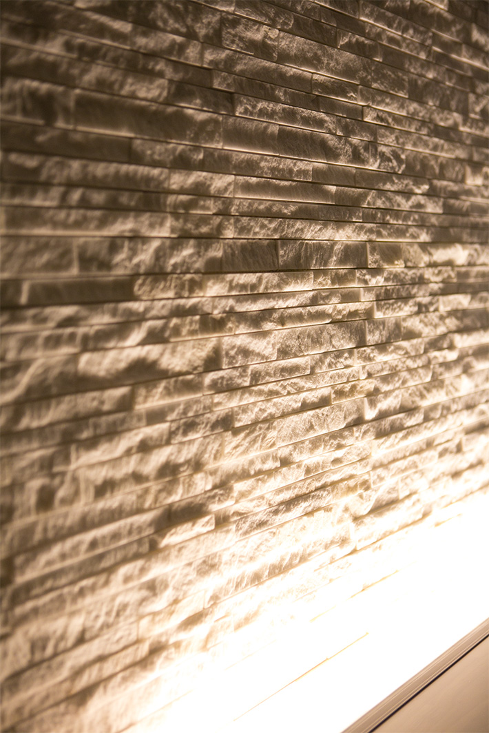 写真：下からの灯に照らされた天然大理石のタイル