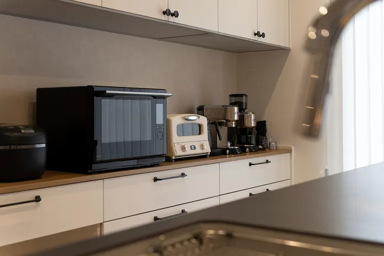 写真:リフォーム後のキッチンの背面にはたっぷり収納のカップボードを設置