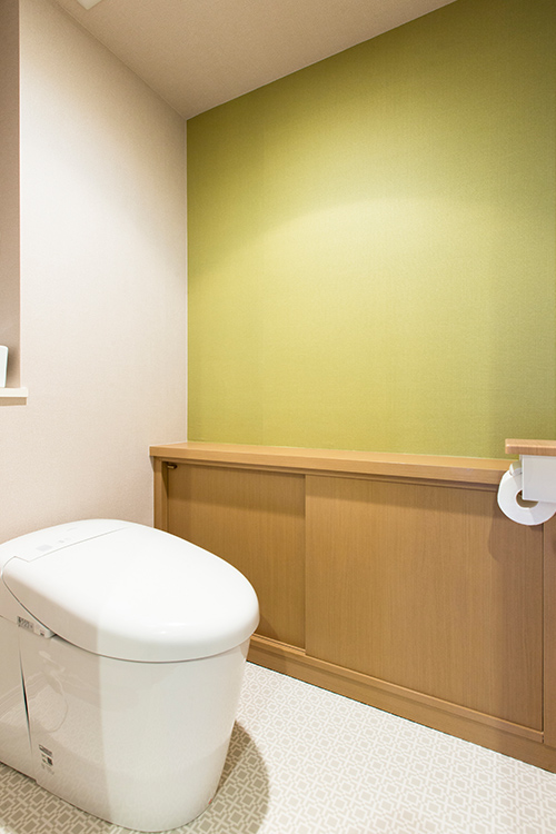 写真：グリーンの壁紙が明るい印象のトイレ
