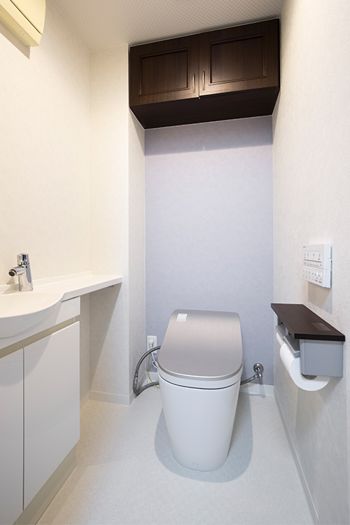写真：ホワイトベースに一部ライトグレーのアクセントクロスが効いているトイレ空間