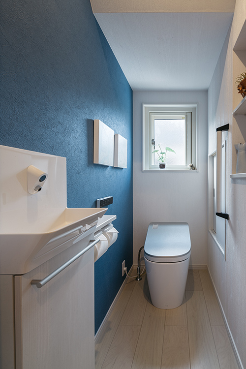 写真：ブルーの壁紙で落ち着いた空間になったトイレ