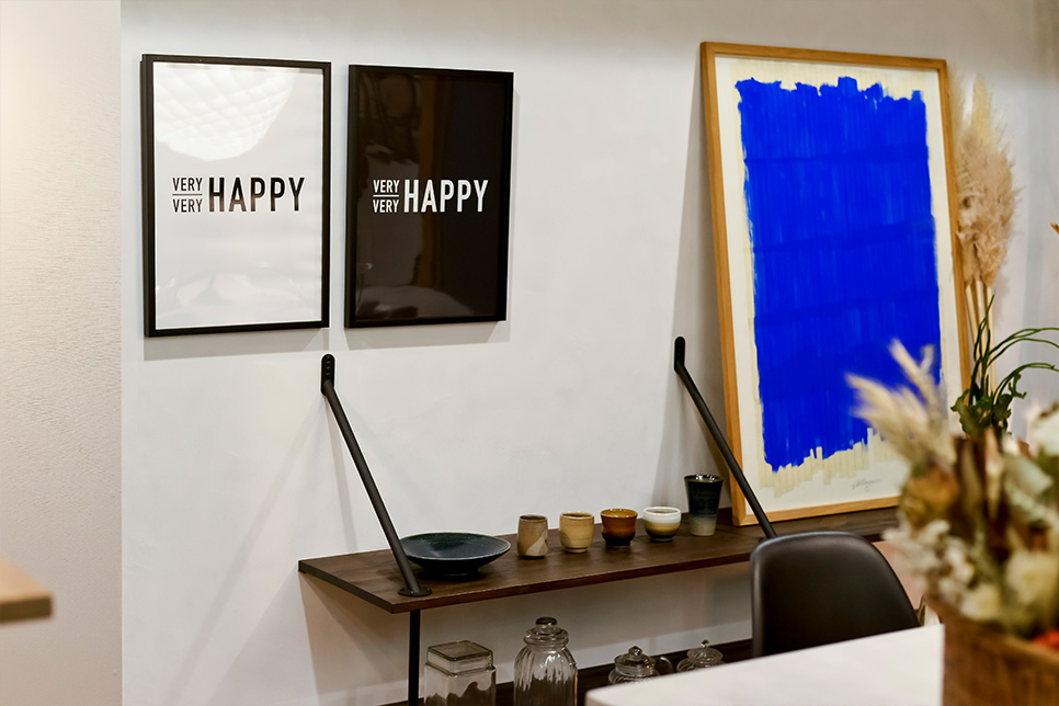 モノトーンを意識したインテリアに似合うフレームと、山口一郎さんの絵画で演出した壁面